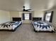 Spacious bedroom with two beds, ceiling fan, and natural light from a window at 2650 Sagebrush Ave, Pahrump, NV 89048