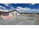 Exterior view of a lovely home with an expansive gravel driveway and detached garage at 2650 Sagebrush Ave, Pahrump, NV 89048