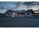 Exterior of house with porch and gravel yard at dusk at 2650 Sagebrush Ave, Pahrump, NV 89048
