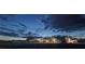 Charming home illuminated at dusk, featuring desert landscaping and a fenced-in yard at 2650 Sagebrush Ave, Pahrump, NV 89048