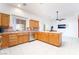 Open kitchen featuring wood cabinets, tiled countertops, stainless steel appliances, and a view of the backyard through a large window at 2650 Sagebrush Ave, Pahrump, NV 89048