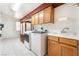 Well-lit laundry room boasts updated appliances, custom cabinetry, and tiled floors for easy maintenance at 2650 Sagebrush Ave, Pahrump, NV 89048