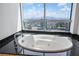 A modern bathroom features a soaking tub with a city and mountain view through a large window at 2700 Las Vegas Blvd # 4305, Las Vegas, NV 89109