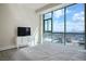 Sunlit bedroom with a large window showcasing city views, complete with a TV and white dresser at 2700 Las Vegas Blvd # 4305, Las Vegas, NV 89109