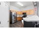 Functional kitchen showcases modern refrigerator, gas range, breakfast bar, and wood cabinetry at 2781 Dunstan Way, Las Vegas, NV 89123