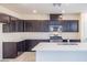 Stylish kitchen with dark cabinetry, stainless steel appliances, and white countertops at 2887 Starling Summit St, Henderson, NV 89044