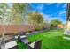 This backyard offers artificial turf, custom planters, and a relaxing seating area perfect for entertaining at 3144 Tronzano Ave, Henderson, NV 89044