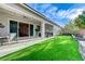 Spacious backyard with artificial turf, a covered patio, and tastefully designed planters at 3144 Tronzano Ave, Henderson, NV 89044