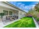 Charming backyard featuring lush artificial turf, a covered patio, and comfortable seating for outdoor relaxation at 3144 Tronzano Ave, Henderson, NV 89044