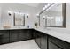 Bathroom features dual vanities with sleek black cabinets and large mirrors at 3144 Tronzano Ave, Henderson, NV 89044