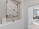 Hallway nook with wall art that leads into a bedroom featuring a cozy chair and ample natural light, decorated beautifully at 3144 Tronzano Ave, Henderson, NV 89044