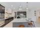Modern kitchen with black cabinets, stainless appliances, and an island with bar seating and decorative pendant lights at 3144 Tronzano Ave, Henderson, NV 89044