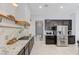 Well-equipped kitchen featuring granite counters, stainless steel appliances, and wooden shelves above a gas range at 3144 Tronzano Ave, Henderson, NV 89044
