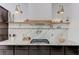 Close-up view of a modern kitchen featuring granite countertops, stainless steel appliances, floating shelves, and stylish lighting at 3144 Tronzano Ave, Henderson, NV 89044