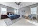 Bright main bedroom featuring light wood floors, modern ceiling fan, and two accent chairs near the window at 3144 Tronzano Ave, Henderson, NV 89044