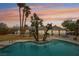 Backyard pool with mature trees, solar panels and a covered patio with seating area at 3155 Duneville St, Las Vegas, NV 89146