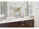 Bathroom featuring a double vanity with mosaic backsplash, dual mirrors, and a glass shower at 3155 Duneville St, Las Vegas, NV 89146