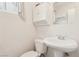 Compact bathroom features a pedestal sink, toilet, and classic white cabinetry at 3155 Duneville St, Las Vegas, NV 89146