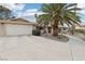 Spacious home featuring an attached garage, palm tree, and well-maintained desert landscaping at 3155 Duneville St, Las Vegas, NV 89146