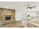 Inviting living room featuring a stone fireplace, wood floors, and an open floor plan with access to the kitchen at 3155 Duneville St, Las Vegas, NV 89146