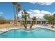 Backyard pool features a diving board and an inviting lounge area surrounded by swaying palm trees and blue skies at 3155 Duneville St, Las Vegas, NV 89146