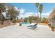 Lounge by the sparkling pool on comfortable chaise lounges in this private backyard oasis, ideal for relaxation at 3155 Duneville St, Las Vegas, NV 89146