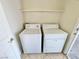 Functional laundry room with a white washer and dryer, and a shelf for storage at 3919 Lilac Haze St, Las Vegas, NV 89147