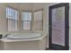 Bathroom featuring a soaking tub by a bay of windows and an exterior door at 4537 Colonial Canyon St, North Las Vegas, NV 89031