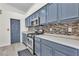Kitchen showcasing updated blue cabinets, stainless steel appliances, and light countertops at 4537 Colonial Canyon St, North Las Vegas, NV 89031