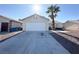 A one-story home with a large garage door and desert landscaping in the front yard at 4651 Wild Oak Way, North Las Vegas, NV 89031