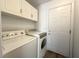 Bright laundry room featuring a washer, dryer, and white cabinets at 4651 Wild Oak Way, North Las Vegas, NV 89031