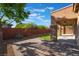Expansive backyard features a covered patio, artificial turf, and brick wall, creating a serene outdoor space at 5384 Candlespice Way, Las Vegas, NV 89135