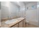 Bathroom featuring double vanity, bathtub with shower, and two windows at 5384 Candlespice Way, Las Vegas, NV 89135