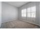Bedroom features neutral paint, carpet, and baseboards, with two windows letting in plenty of light at 5384 Candlespice Way, Las Vegas, NV 89135