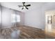 A bright bedroom featuring wood-look floors, ceiling fan, and large window at 5384 Candlespice Way, Las Vegas, NV 89135