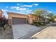 Inviting home with a two-car garage, desert landscaping, and stone accents offers a modern and stylish exterior at 5384 Candlespice Way, Las Vegas, NV 89135