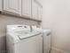 Laundry room features a washer and dryer with grey shaker cabinets for storage at 5384 Candlespice Way, Las Vegas, NV 89135