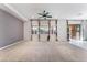 Large living room with plush carpet, a ceiling fan, and abundant natural light from multiple windows at 5384 Candlespice Way, Las Vegas, NV 89135