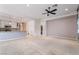 Open-concept living space with carpet flooring, a ceiling fan, and seamless flow to the modern kitchen at 5384 Candlespice Way, Las Vegas, NV 89135