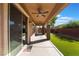 Inviting covered patio with ceiling fans and well-maintained artificial turf creates a perfect outdoor retreat at 5384 Candlespice Way, Las Vegas, NV 89135