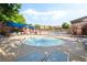 Community splash pool with fountain feature, lounge chairs, and covered seating areas for residents' enjoyment at 5384 Candlespice Way, Las Vegas, NV 89135