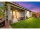 Spacious backyard features a covered patio, artificial grass, a built in grill, and comfortable seating at 5530 Hill Spire St, Las Vegas, NV 89166