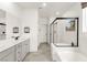 Bright bathroom with double vanity, bathtub, glass shower, and modern fixtures at 5530 Hill Spire St, Las Vegas, NV 89166