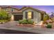 Charming home boasts a manicured lawn, stone accents, desert landscaping, and a two-car garage at 5530 Hill Spire St, Las Vegas, NV 89166