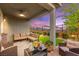 Covered patio features comfortable lounge seating, ceiling fan, and views of the landscaped backyard at 5530 Hill Spire St, Las Vegas, NV 89166