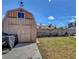 A spacious backyard featuring a weathered barn, lush green grass, and a durable concrete patio at 5731 Fonchester Ct, Las Vegas, NV 89110