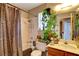 Bathroom with shower-tub combo, patterned shower curtain, wooden vanity, and greenery at 5731 Fonchester Ct, Las Vegas, NV 89110