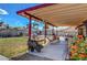 Comfortable covered patio with ample seating, flowering plants, and views of the fenced backyard at 5731 Fonchester Ct, Las Vegas, NV 89110