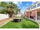 A backyard that features artificial turf, a fire pit and seating area at 5769 Larkdale St, Las Vegas, NV 89120