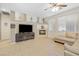 Spacious living room with a fireplace, large windows, ceiling fan, and plush sectional sofa at 5769 Larkdale St, Las Vegas, NV 89120